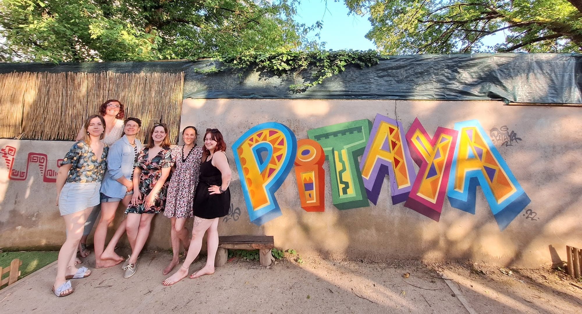 L'équipe de la micro-crèche Pitaya devant la fresque du jardin, à Besançon